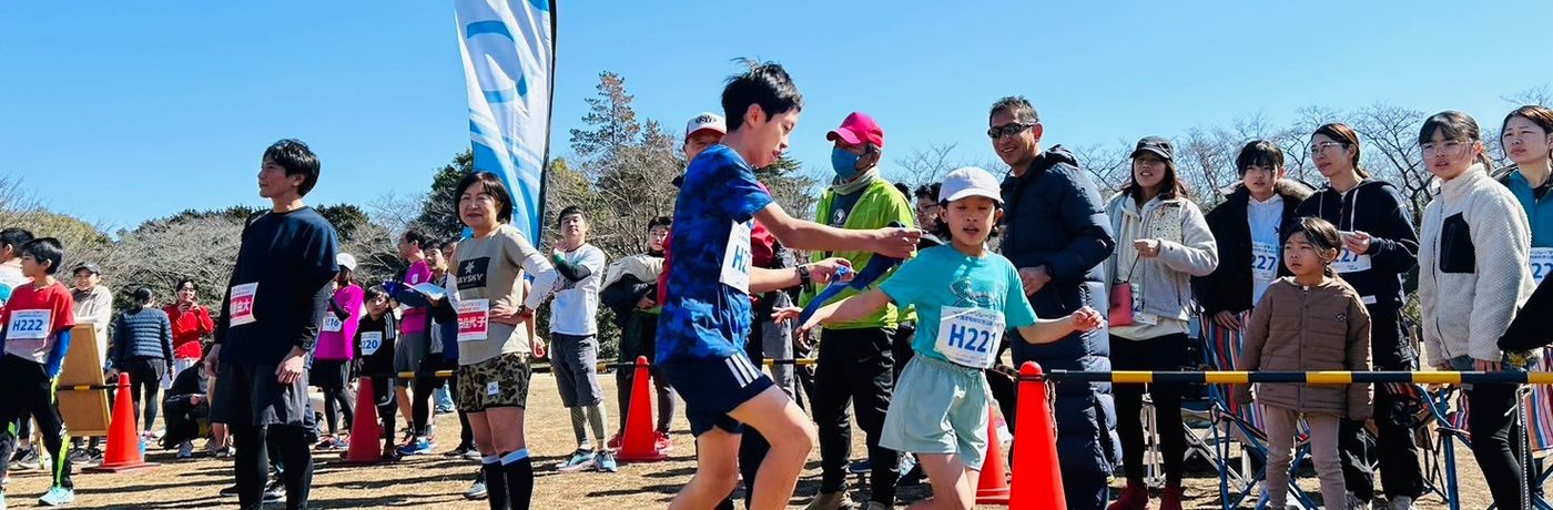 リレーマラソンの中継所でたすきを受け渡す参加者